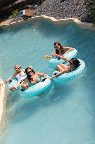 a group of people riding on tubes in a swimming pool at Hyatt Regency Lost Pines Resort and Spa in Cedar Creek