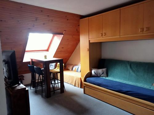 a bedroom with a bunk bed and a table with a desk at joli studio vue montagne in Allos