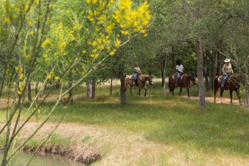 a group of people riding horses in the woods at Hyatt Regency Lost Pines Resort and Spa in Cedar Creek