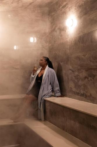 a woman sitting on a ledge with a glass of wine at Hyatt Regency Lost Pines Resort and Spa in Cedar Creek