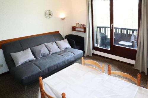 d'un salon avec un canapé et un balcon. dans l'établissement Résidence Le Pouzenc - Studio 6 personnes accès direct aux pistes MAE-3921, aux Orres