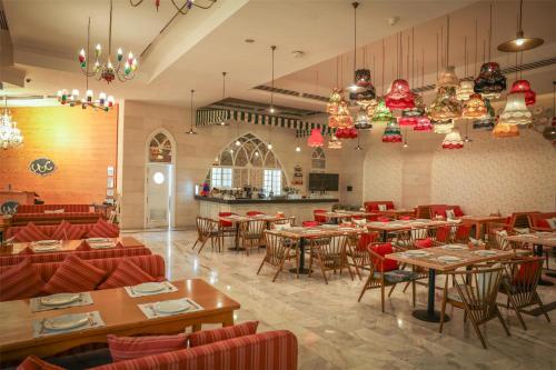 a restaurant with tables and chairs in a room at Kempinski Al Othman Hotel Al Khobar in Al Khobar