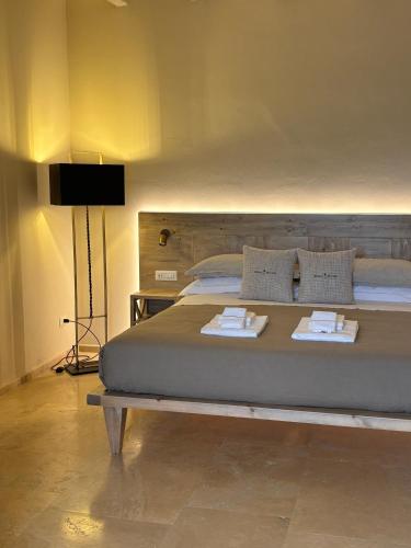 a bedroom with a large bed with two towels on it at Relais dei Molini - Villa dei Molini in Castagneto Carducci