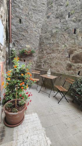 a patio with a table and chairs and flowers at Casa Vacanze Uno Sguardo Sul Borgo in Montecatini Val di Cecina