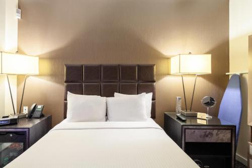 a hotel room with a large bed with two lamps at The Historic Blue Angel Hotel Lexington Ave, an Ascend Collection in New York