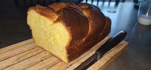 un pain sur une planche de découpe avec un couteau dans l'établissement Jolie maison entière 2 chambres 1 jardin, à Saints-Geosmes