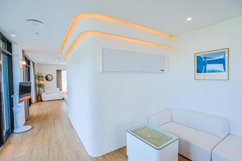 a living room with a couch and a wall at Paul Mare Pool Villa in Busan