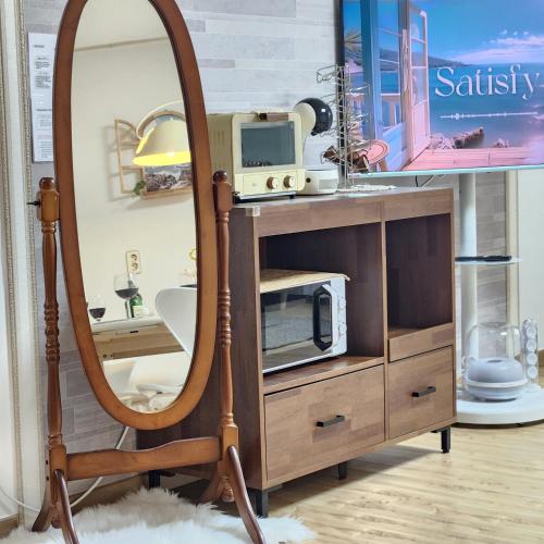 a mirror in front of a dresser with a tv at Lake House in Hwaseong
