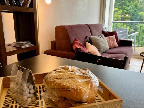une table avec une boîte de pain et un canapé dans l'établissement Rue des Présidents - 2-4 pers - 300m de la mer, à Les Sables-dʼOlonne