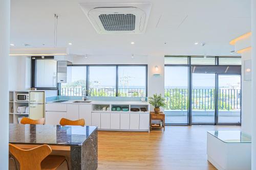 a kitchen with white cabinets and a table with chairs at Paul Mare Pool Villa in Busan