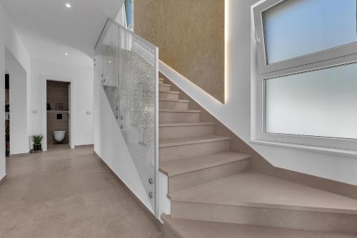 a staircase in a house with a window at Villa Solas Lux Makarska - Veliko Brdo in Veliko Brdo
