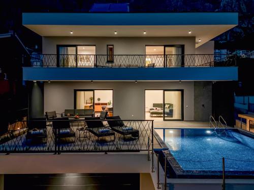 a large house with a swimming pool in front of it at Villa Solas Lux Makarska - Veliko Brdo in Veliko Brdo