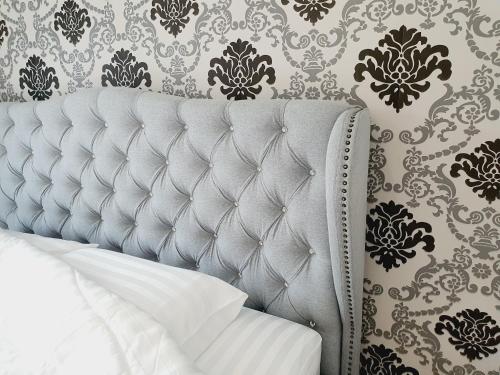 a bed in a bedroom with a wall with wallpaper at Comfy Townhome 5min walk to 7-11 in Ban Nong Bua