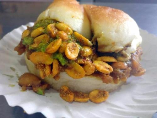 a close up of a sandwich with beans on a plate at Hotel Classique, Rajkot in Rajkot