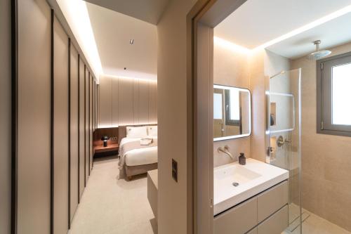 a bathroom with a white sink and a mirror at Kyma Luxury Apartment in Rhodes Town