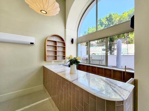 a bathroom with a large window and a counter with flowers at Lavish Living at The Braemar in Cape Town