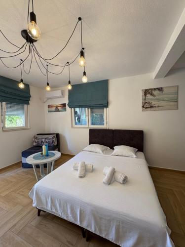 a bedroom with a large bed with two towels on it at Studio apartman Happy Home in Tivat