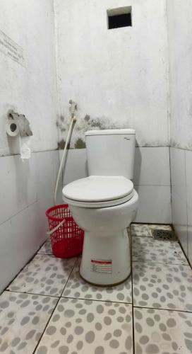 a bathroom with a toilet and two red baskets at Mây House – Sống Lưng Khủng Long in Bắc Yên