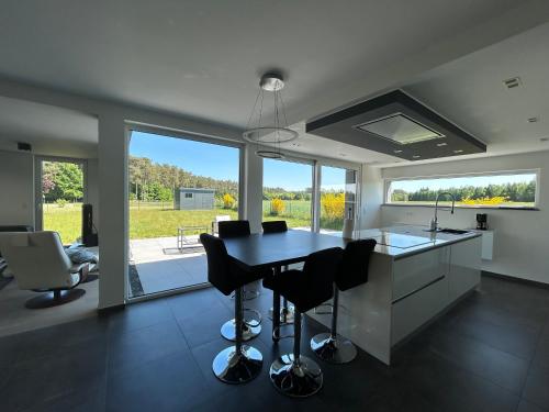 a kitchen with a table and chairs and a large window at Chambre à la campagne 