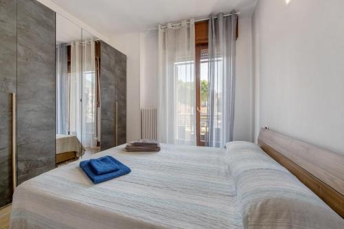 a bedroom with a large bed with a blue towel on it at Casa Sandrina Tra Montagna e Lago in Caprino Veronese