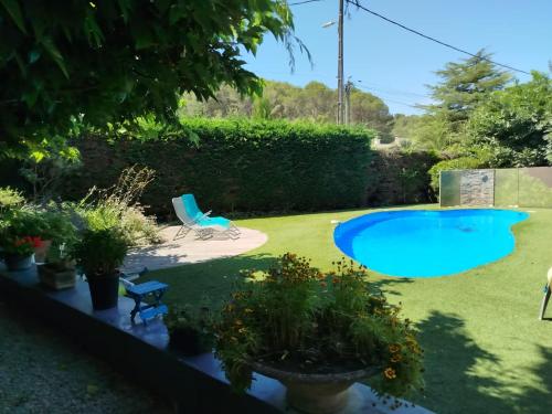 une cour arrière avec une piscine bleue et quelques plantes dans l'établissement Villa plein pieds 8 personne piscine reste semaine juillet août, à Simiane-Collongue