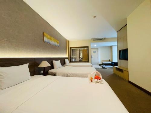 a hotel room with two beds and a television at Muong Thanh Grand Quang Tri Hotel in Quang Tri