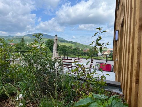 - un balcon avec un parasol, une table et des chaises dans l'établissement La Terrasse du Vignoble - Garage et parking privatifs, à Barr