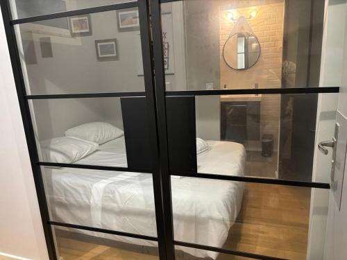 une chambre avec une cloison en verre et un lit dans l'établissement T2 RdC avec parking, plage à 50m, à Arcachon