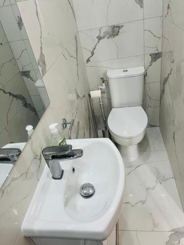 une salle de bain blanche avec des toilettes et un lavabo dans l'établissement Maison du pêcheur Normand, à Trouville-sur-Mer