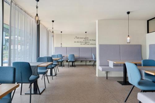 a waiting room with blue chairs and tables at Seaberhof Kaltern in Caldaro
