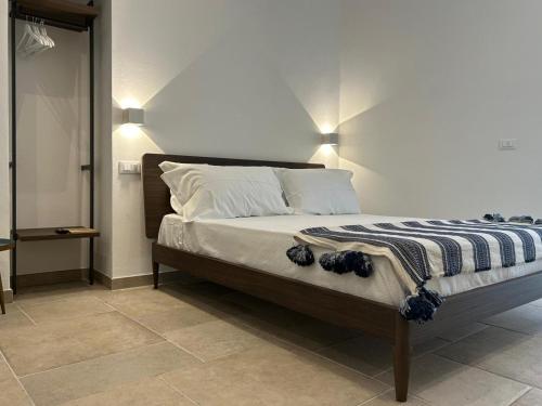 a bedroom with a bed with a striped blanket on it at Joivy Dimore Rodiane - Ponente in Rodi Garganico