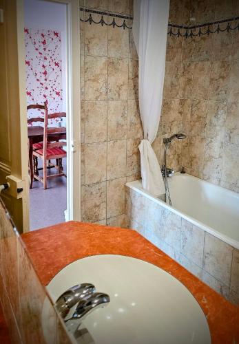 une salle de bain avec un lavabo et une baignoire dans l'établissement Le conquérant - chambres meublées - Barfleur, à Barfleur