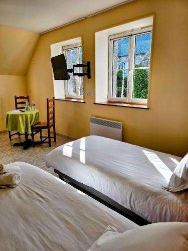 - 2 lits dans une chambre avec une table et 2 fenêtres dans l'établissement Le conquérant - chambres meublées - Barfleur, à Barfleur