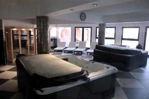 une grande pièce avec un jacuzzi et des chaises dans l'établissement appartement à Anglet, à Anglet