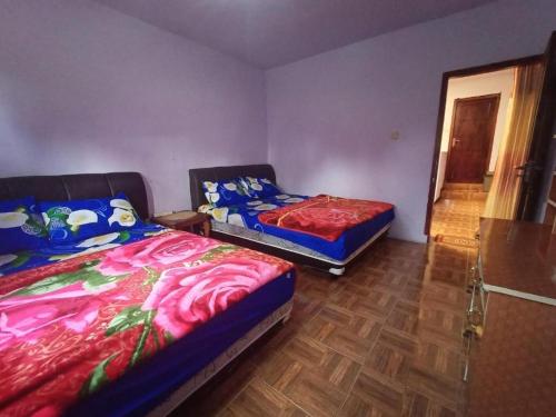 a bedroom with two beds and a door to a hallway at Elen Villa by ABM in Ngadisari