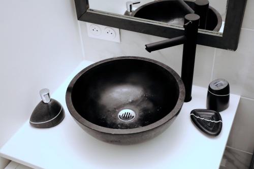 - un lavabo noir sur un comptoir dans la salle de bains dans l'établissement appartement à Anglet, à Anglet