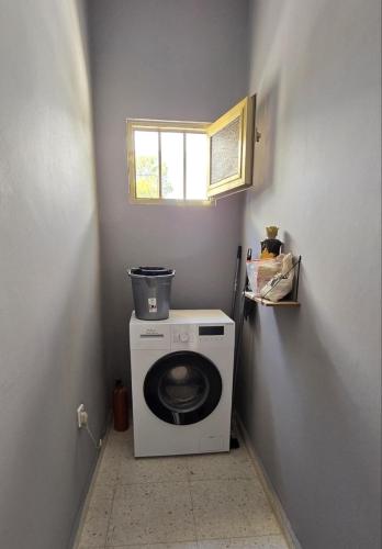 a small bathroom with a washing machine and a window at Sun Wave Villa Sea View Retreat in Peyia