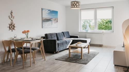 a living room with a couch and a table at Na Wydmie, Sun & Snow in Ustka
