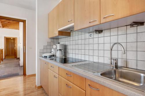 a kitchen with wooden cabinets and a sink at Seaberhof Kaltern in Caldaro