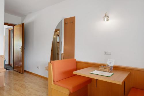 a room with a chair and a table and a refrigerator at Seaberhof Kaltern in Caldaro