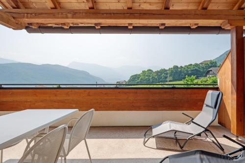 a table and chairs on a balcony with a view at Seaberhof Kaltern in Caldaro