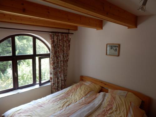 a bedroom with a bed in front of a window at Luxe Appartement Hertvíkovice in Vlcice