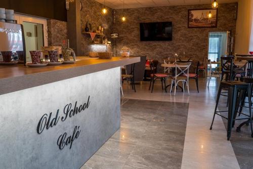 a bar in a restaurant with tables and chairs at Old School Inn penzion in Beluša