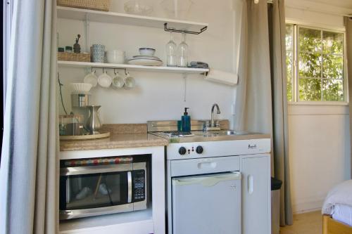 a kitchen with a sink and a microwave at 30 PCT OFF! Malibu Charming Suite, Ocean View, King Bed in Malibu