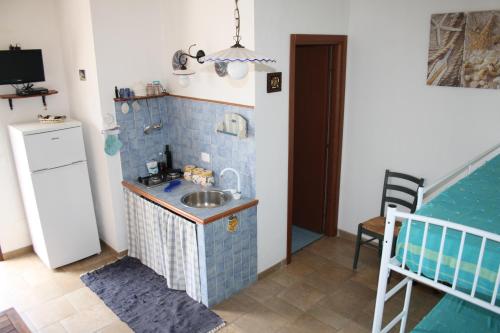 een keuken met een wastafel en een koelkast bij Villa Rossana in Scopello