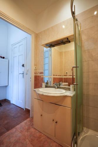 une salle de bain avec un lavabo et un miroir dans l'établissement Coeur de Nice - Plage et Centre, à Nice