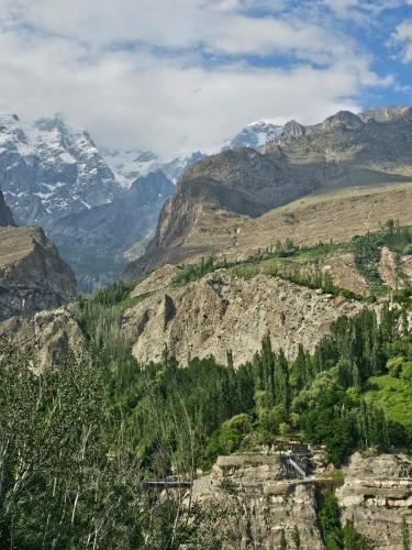 a view of a mountain valley with snow covered mountains at The Backpackers' Nest Hunza in Hunza