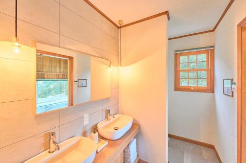 a bathroom with two sinks and a mirror at プライベートリゾート飛鳥 in Atami