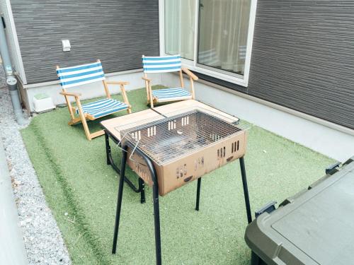 two chairs and a table sitting on a lawn at Base in Onnason,Okinanawa in Onna