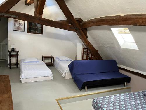 une chambre mansardée avec deux lits et une fenêtre dans l'établissement coeur de ville, à Beaugency